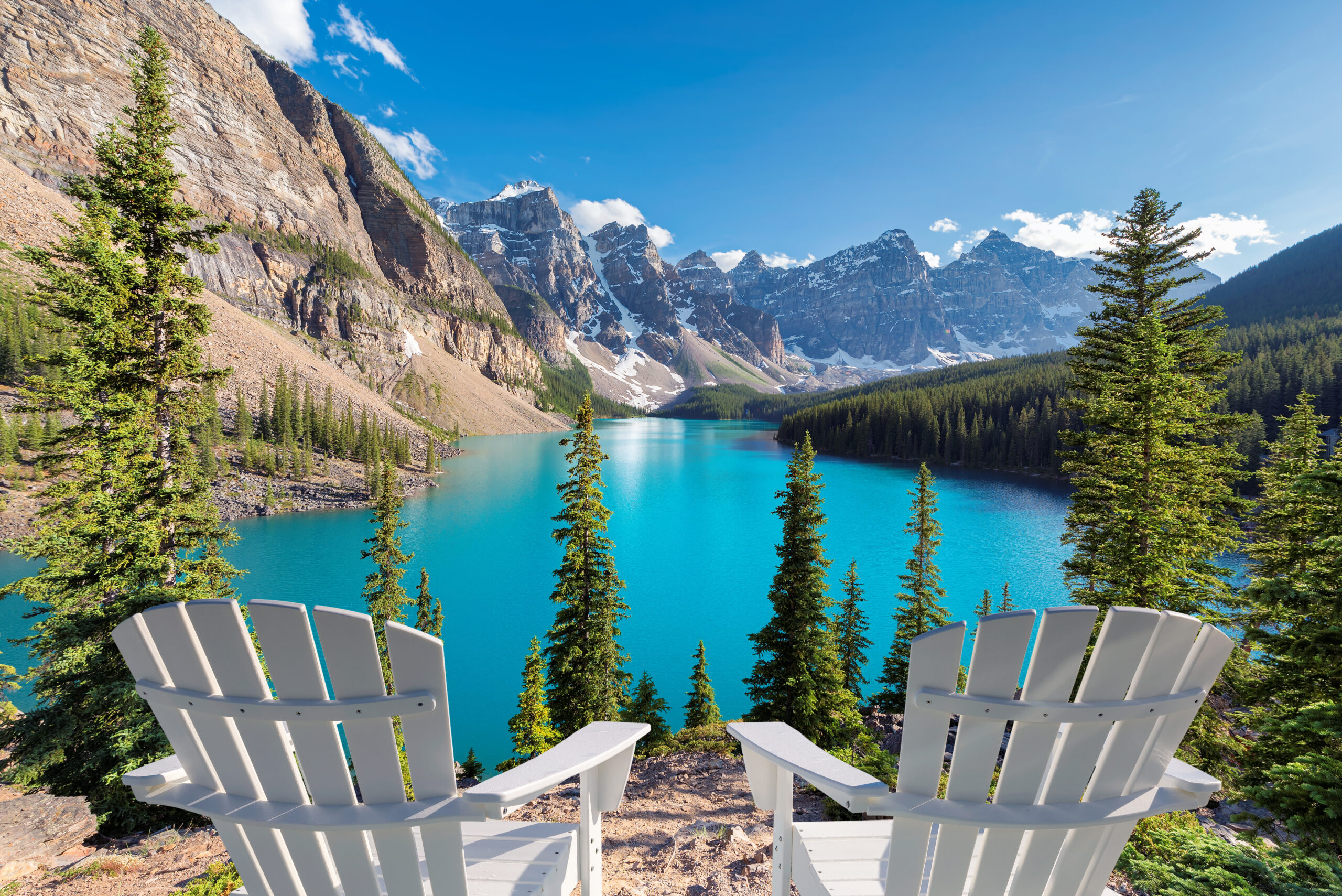 Beautiful turquoise waters of the Moraine Lake at sunset with snow-covered peaks above it in Rocky Mountains, Banff National Park, Canada.